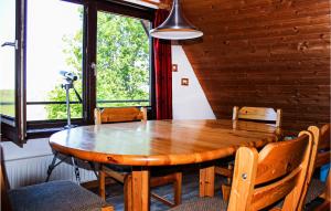 a wooden dining room table with chairs and a large window at 2 Bedroom Cozy Apartment In Otterndorf in Otterndorf +8 photos