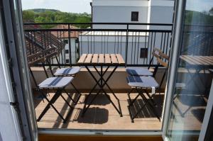 a balcony with a picnic table and chairs at Apartman Ras in Vrnjačka Banja
