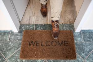 a person in brown shoes standing on a welcome mat at Apartments Bells of Ljubljana - 3 cosy apartment Private Free Parking in Ljubljana