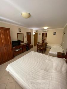 a bedroom with a large white bed and a television at Sozopol Santa Marina Sea View Studio in Sozopol +44 photos