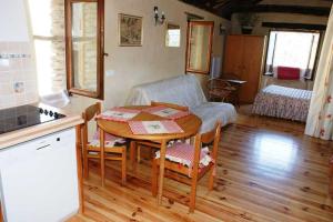 a kitchen with a table and a living room at Gîte Maison Cavalier 2/4 personnes à Gabriac in Gabriac