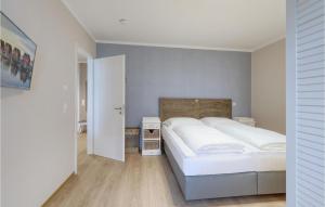 - une chambre avec 2 lits blancs et une porte dans l'établissement Baltischer Hof Apartment 15, à Boltenhagen
