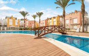 a bridge over a swimming pool with palm trees and buildings at Charming Apartment With Pool in Vera