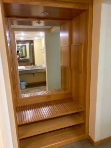 a bathroom with a mirror and a wooden closet at Sol Alphaville Flat completo lazer cama casal in Barueri +17 photos