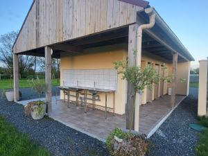a building with a wooden deck with a table at Camping Aire Natuelle d'Agy in Agy