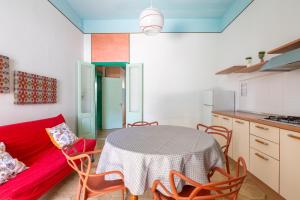a kitchen with a table and a red couch at Casa Tonio by BarbarHouse in Taviano +8 photos