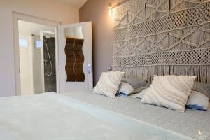 a bedroom with a bed with pillows and a shower at Les Pins Perdus in Saint-Ciers-dʼAbzac