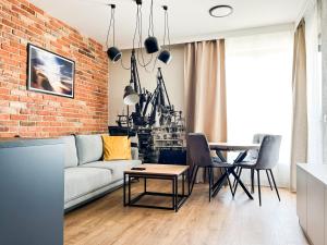 een woonkamer met een bank en een bakstenen muur bij Mint Apartments Gdańsk DOKI in Gdańsk