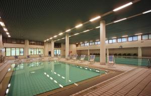 uma grande piscina interior com cadeiras e uma piscina em TH La Thuile - Planibel Residence em La Thuile