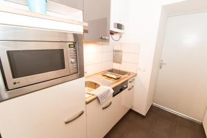 a kitchen with a stove, microwave and refrigerator at CheckVienna - Diefenbachgasse in Vienna