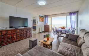ピネダ・デ・マールにあるNice Apartment In Pineda De Marの大きなテレビとテーブルのあるリビングルーム