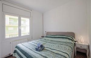 ピネダ・デ・マールにあるNice Apartment In Pineda De Marのベッドルーム1室(毛布、窓付)