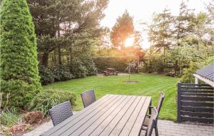 a wooden table with chairs and a picnic table in a yard at Gorgeous Home In Hemmet With Wifi in Hemmet