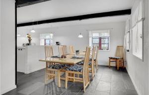 a kitchen and dining room with a wooden table and chairs at Two-Bedroom Holiday Home Sydals With A Fireplace 03 in Vollerup