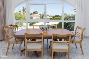een eetkamer met een tafel en stoelen en een raam bij Casa Delfin - Moraira in Moraira