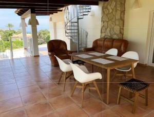een eetkamer met een tafel en witte stoelen bij Casa Delfin - Moraira in Moraira