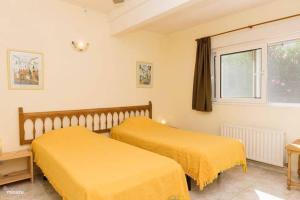 twee bedden in een kamer met gele lakens bij Casa Delfin - Moraira in Moraira +2 foto's