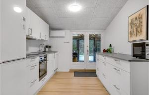 セビーにあるAwesome Home In Sæby With Wifiの白いキャビネットと木製の床を備えたキッチン