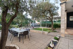 einen Tisch und Stühle auf einer Terrasse mit Bäumen in der Unterkunft Holiday Home DaLeo in Zadar