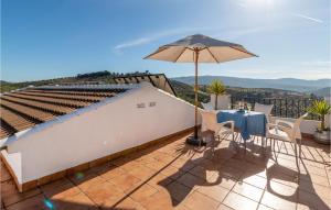 a patio with an umbrella and a table and chairs at 4 Bedroom Stunning Home In Iznajar in Iznájar +18 photos