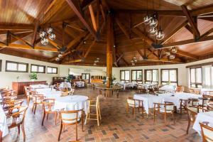 a dining room with white tables and wooden ceilings at Hotel Estancia Betania in Colombo