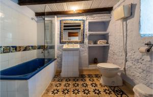 a bathroom with a blue tub and a toilet at Lovely Home In Cazalla De La Sierra in Cazalla de la Sierra +20 photos