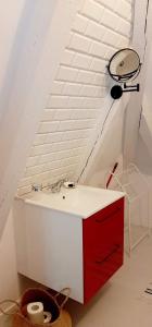 ein Badezimmer mit einem rot-weißen Waschbecken auf einem Dachboden in der Unterkunft Dom nad morzem in Pobierowo + 46 Fotos
