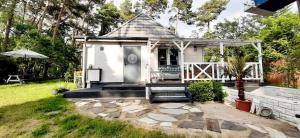 ein kleines weißes Haus mit einer Veranda und einer Terrasse in der Unterkunft Dom nad morzem in Pobierowo