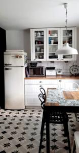 eine Küche mit einem weißen Kühlschrank und einem Tisch in der Unterkunft Dom nad morzem in Pobierowo