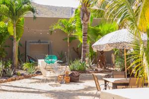 a patio with tables and chairs and palm trees at Pure Baja Private Suites-Upscale Property with Infinity Pool and Lush Gardens in El Pescadero
