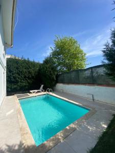 a swimming pool with a chair next to a house at Sapanca Manzara Villa 1 Isıtma Havuzlu in Sapanca