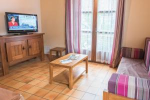 a living room with a tv and a table at Gîte Gîtes de France 3 épis 5/6 personnes à Chirac in Chirac