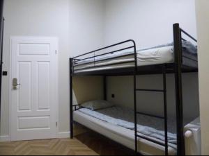 two bunk beds in a room with a door at GINGERBREAD Hostel in Toruń