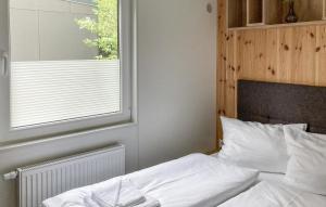 a bedroom with a white bed with a window at Tiny Haus 73 Am Brombachsee in Pleinfeld +29 photos