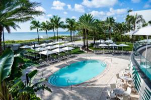 una vista aérea de una piscina del complejo con sombrillas y el océano en Eden Roc Miami Beach, en Miami Beach