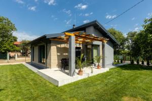 a small house with a patio and green grass at Summerland 1 in Krapets