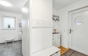 a kitchen with white cabinets and a white door at Nice Home In Tossens With Kitchen in Tossenserdeich