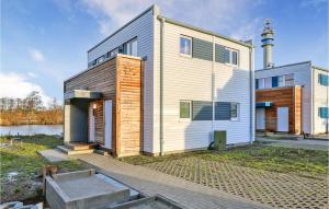 a house with a lighthouse in the background at Nice Home In Tossens With Kitchen in Tossenserdeich
