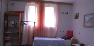 a bedroom with a window with pink curtains at Private Room & Terrace in Skopje