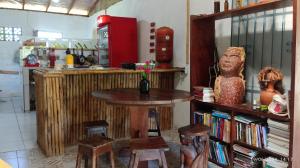 a kitchen with a table and a book shelf with books at Eco Hostel Lunar - Hospedagem Rural - Entrada pelo Sitio da familia Cassiano -Tucumanduba in Soure