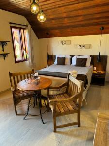 a bedroom with a bed and a table and chairs at Pousada Villarejo in Monte Verde +54 photos