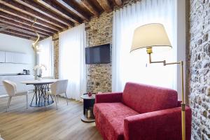 a living room with a red couch and a table at SARPI Apartment & Suite in Udine