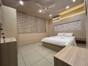 una camera da letto con un letto e un ventilatore a soffitto di Famstay and healthclub a Kannur Altre 13 foto