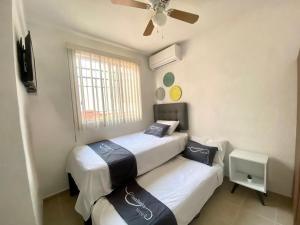 a bedroom with two beds and a ceiling fan at LA CASABONITA vistalberca AirA in Alpuyeca +59 photos