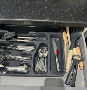a tray filled with utensils sitting on a counter at Cosy 4 bedroom holiday let Stevenage 22mins from London on the train in Stevenage