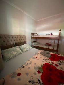 a bedroom with a bed and a table with roses on it at Pousada do Maninho in Penha +16 photos