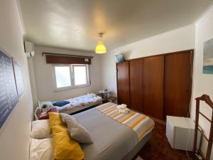 a bedroom with two beds and a window at Guest House Patrocinio in Corroios