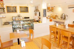 a restaurant with tables and a person in the kitchen at Bloomrooms @ Link Road in New Delhi