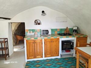 a kitchen with a stove and a microwave at La Campagne Saint Jean in Baudinard