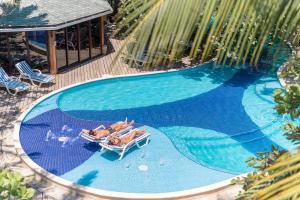 una vista sul soffitto di una piscina con 2 sedie a sdraio di Paradise Beach Hotel & Resort a West Bay